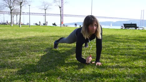 Sporty-girl-training-on-green-lawn-in-park